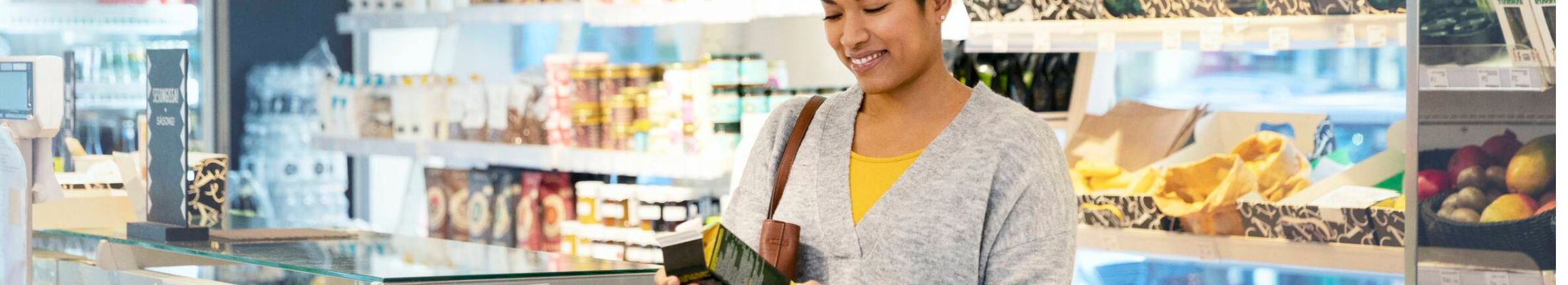 Woman in grocery store choosing a renewable packaging. 