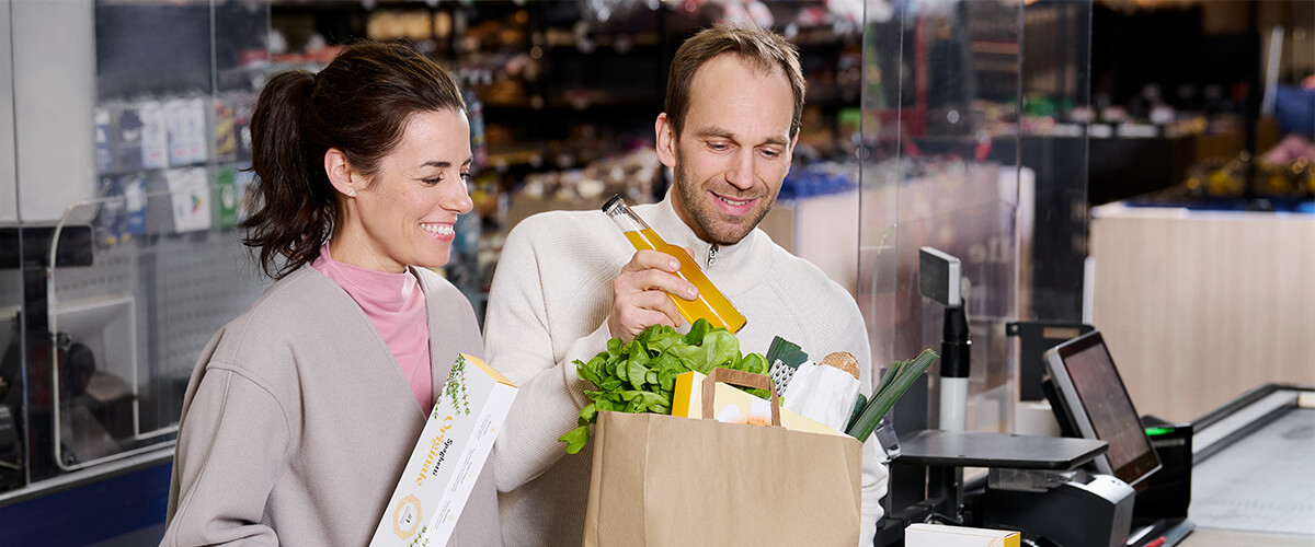 Couple put groceries in paper bag