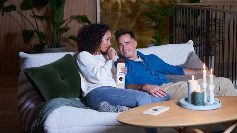 A couple sharing chocolate in the sofa