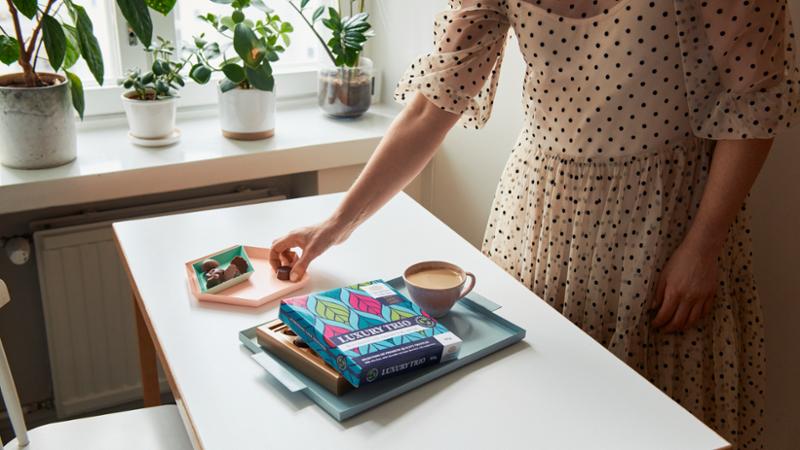 A woman taking a piece of chocolate from the table