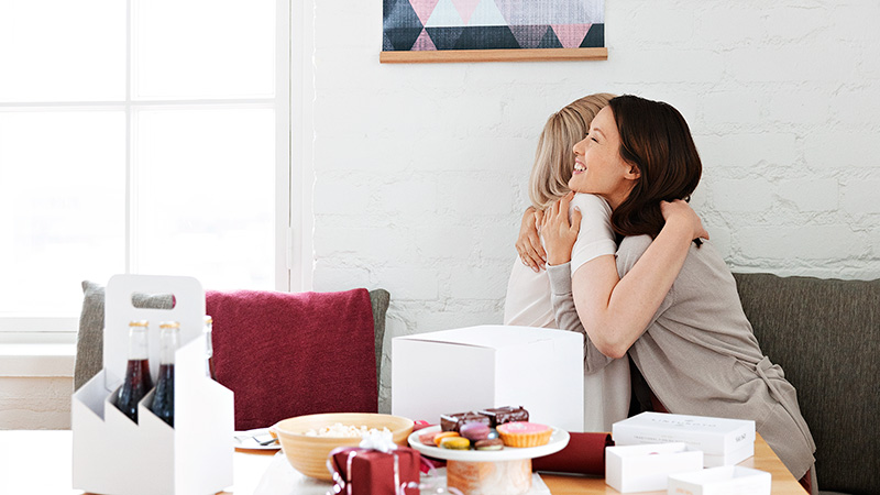 Two people hugging and having snacks in the sofa