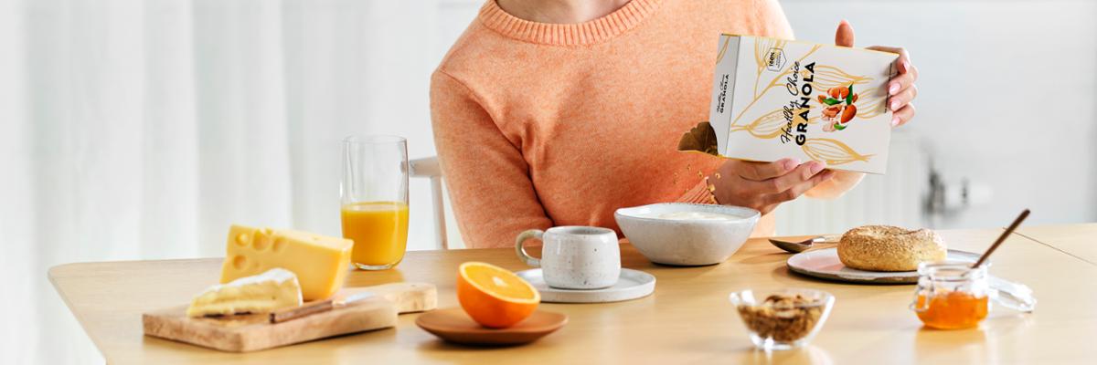 Young woman having cereal at breakfast table
